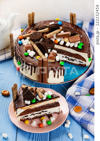 Plate of sweet chocolate cake with bisquits and candies at decorated wooden table background. 122232459