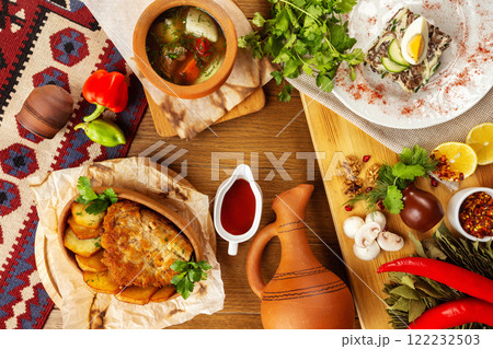 Top view image of traditional georgian lunch with various meals and ingredients at decorated wooden table background. Top view image of traditional georgian lunch with various meals and ingredients at decorated wooden table background. 122232503
