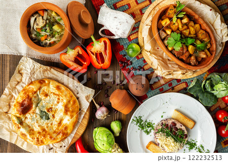 Top view image of traditional georgian lunch with various meals and ingredients at decorated wooden table background. 122232513