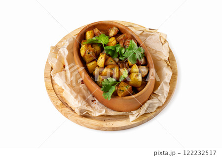 Cruze pot with stew beef and potato served on a cooking paper at wooden board isolated at white background. Cruze pot with stew beef and potato served on a cooking paper at wooden board isolated at white background. 122232517