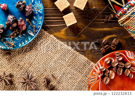 Colorful set of plates wiith spice, herb, coffee beans and sugar at wooden board background as natural wallpaper. 122232613