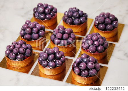 Closeup group of delicious tarts with berries served on golden paper. Restaurant sweet bakery. Closeup group of delicious tarts with berries served on golden paper. Restaurant sweet bakery. 122232632