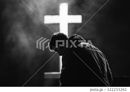 Christian man praying in front of the cross 122233262