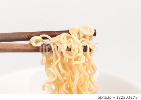 Instant noodles on a plate and chopsticks spoon isolated on white background 122233275