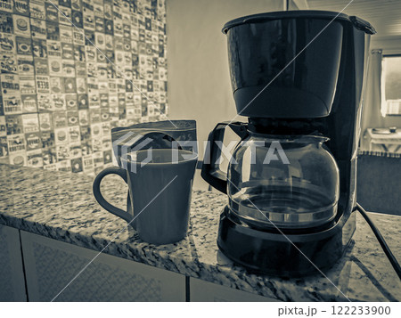Coffee machine and red cup on table in the kitchen. 122233900