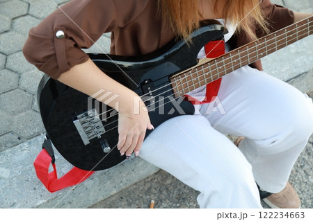 Girl Plays The Bass Instrument Sitting On The Step Near The Street At Evening 122234663
