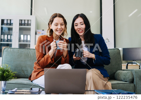 Female colleague caucasian descent holds a cup of coffee and talking discussion ideas and happily. Female colleague caucasian descent holds a cup of coffee and talking discussion ideas and happily. 122235476