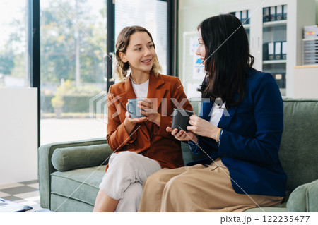 Female colleague caucasian descent holds a cup of coffee and talking discussion ideas and happily. 122235477