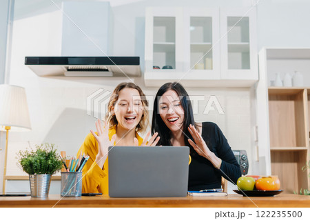 Happy smiling two woman sitting in the kitchen, feel happy successful work complete. Happy smiling two woman sitting in the kitchen, feel happy successful work complete. 122235500