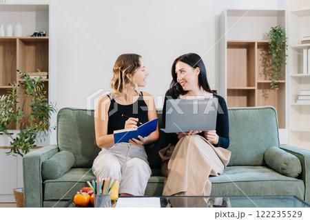 Office Lifestyle: Two Woman Reviews Business Project at Home Office. 122235529
