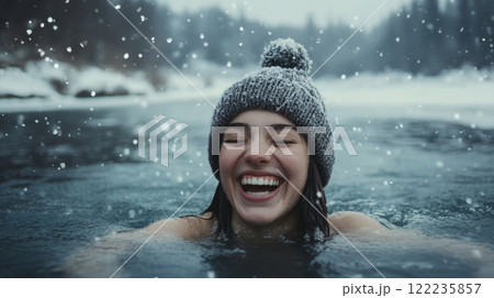 Joyful woman swimming outdoors in snowy winter landscape. 122235857
