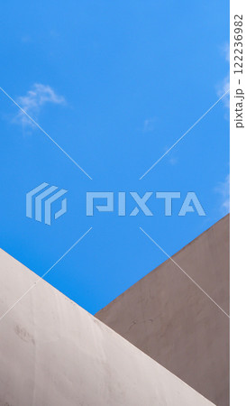 Geometric Contrast. A composition highlighting the intersection of angular concrete structures against a bright blue sky, emphasizing simplicity and sharp modern aesthetics Geometric Contrast. A composition highlighting the intersection of angular concrete structures against a bright blue sky, emphasizing simplicity and sharp modern aesthetics 122236982