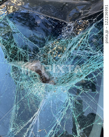 An Intricate Close Up View of Cracked Glass Featuring a Unique Spiderweb Pattern Design 122236991