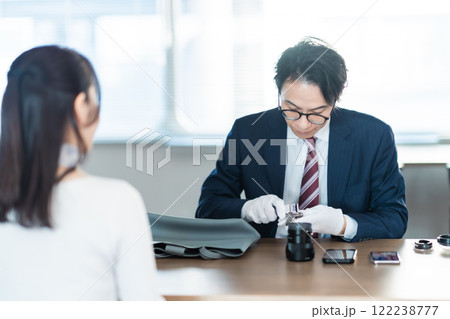 中古時計の査定をする買取業者と主婦 中古時計の査定をする買取業者と主婦 122238777