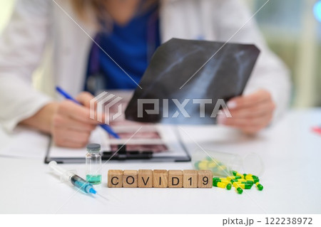 A Medical Professional is Conducting a Thorough Review of COVID19 Xray and Test Results 122238972