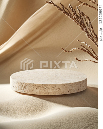 A rough stone slab sits on a sandy surface, surrounded by leaves casting shadows. The scene evokes a desert or tropical environment, highlighting the interplay of light and natural textures. 122239974