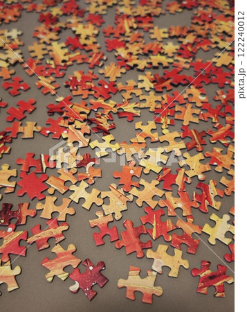 Christmas puzzle with warm orange and red colors waiting to be assembled 122240012