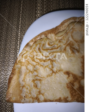 Folded crepe on white plate resting on placemat Folded crepe on white plate resting on placemat 122240054