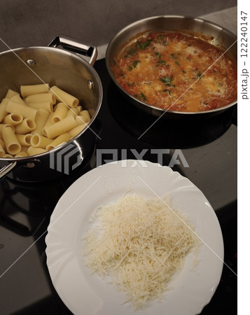 Chef preparing rigatoni pasta with tomato sauce and grated cheese in prague 122240147