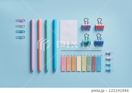 Pastel-colored stationery neatly arranged on a light blue background. Workplace organization. Back to school concept. 122241848