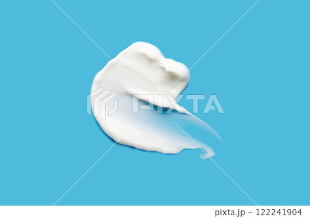 A sample of white cosmetic moisturizer on a blue background 122241904