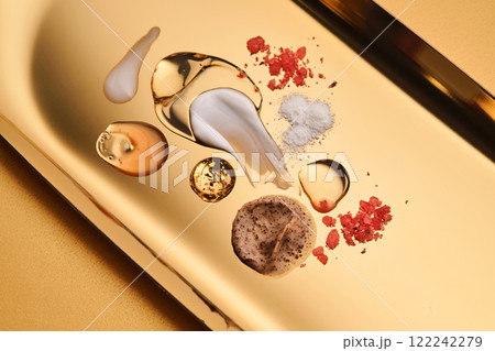 Textures of different cosmetic products on a gold background. 122242279
