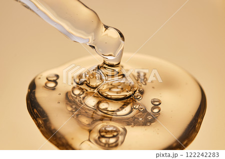 A pipette with a beautiful drop of gel-textured facial serum. A pipette with a beautiful drop of gel-textured facial serum. 122242283