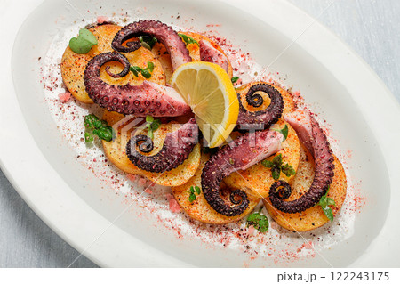 Octopus with potatoes and spices , on a light plate, top view, no people, homemade, close-up, 122243175