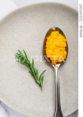 Yuzu caviar is pearly, on a spoon, top view, light background, no people. 122243187