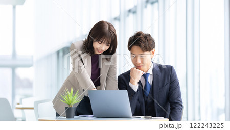 パソコンを使ってミーティングをする男女2人のビジネスマン 122243225