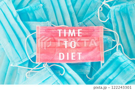 Pile of blue surgical masks with pink writing that says Time to Diet 122243301
