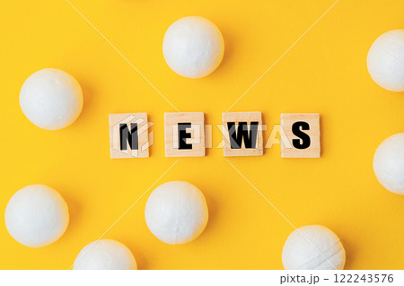 A yellow background with a large group of white balls scattered around it 122243576