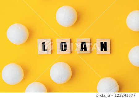 A yellow background with white balls and the word loan written in black A yellow background with white balls and the word loan written in black 122243577