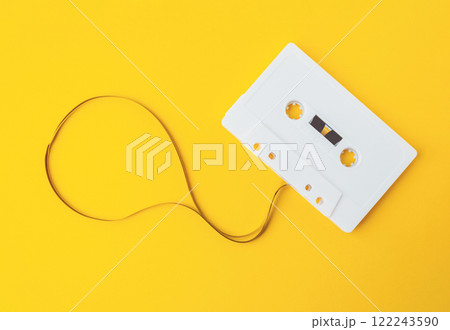A white cassette tape is laying on a yellow background A white cassette tape is laying on a yellow background 122243590