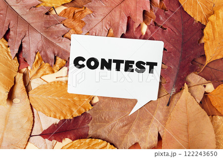 Autumn leaves with contest card and clock on a rustic background 122243650