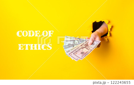 A hand holding a stack of money with the words Code of Ethics written below it 122243655