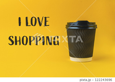 Coffee cup with a black lid sits on a yellow background 122243696