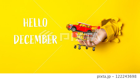 Hand holding a toy car in front of a yellow background Hand holding a toy car in front of a yellow background 122243698