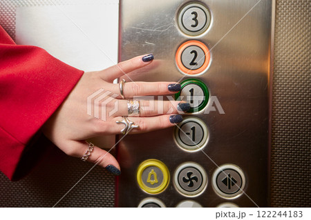 Pressing the elevator button in contemporary high rise buildings signifies modern urban convenience 122244183