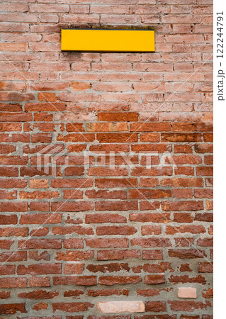 Rustic brick wall with a vibrant yellow sign Rustic brick wall with a vibrant yellow sign 122244791