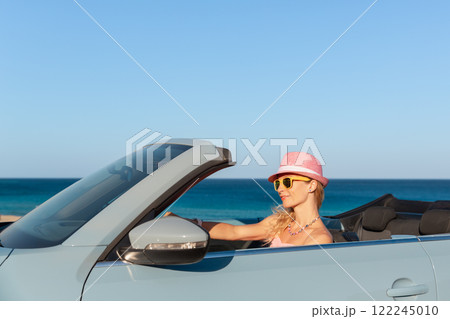 Happy young woman travel by car by the sea 122245010