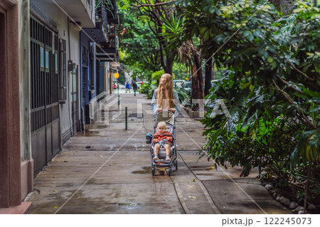 Mother with her son exploring lush streets of Condesa, Mexico City. Family adventure in a vibrant urban oasis. Travel, family bonding, and urban greenery concept in Latin America 122245073