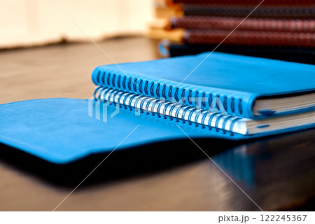Open Spiral-Bound Blue Notebooks on Wooden Surface. 122245367