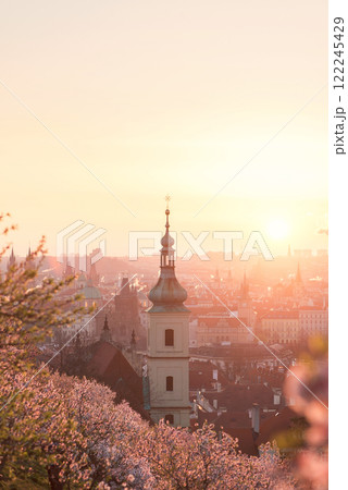 Baroque chapel bell tower steeple at historical part of city on the background of an orange red sunrise sky. 122245429