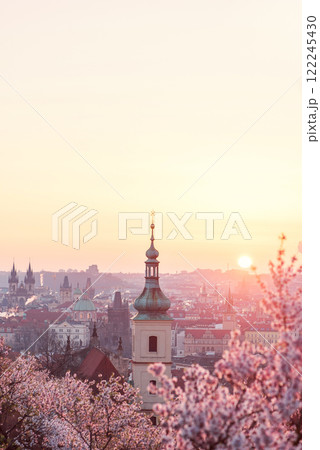 Baroque chapel bell tower steeple at historical part of city on the background of an orange red sunrise sky. 122245430