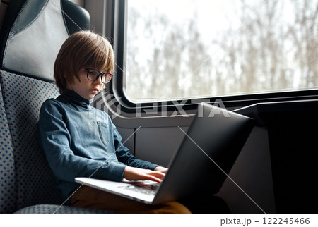 Young Boy Working on a Laptop in a Train. Young Boy Working on a Laptop in a Train. 122245466