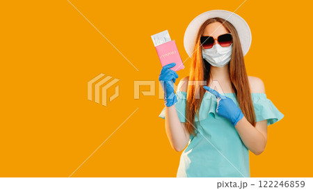 Pandemic travel. Global immigration. Woman tourist in protective face mask gloves showing id passport flight ticket isolated on orange copy space background. 122246859