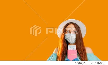Pandemic journey. Quarantine vacation. Happy woman in protective face mask gloves with passport flight ticket isolated on orange copy space background. Pandemic journey. Quarantine vacation. Happy woman in protective face mask gloves with passport flight ticket isolated on orange copy space background. 122246880