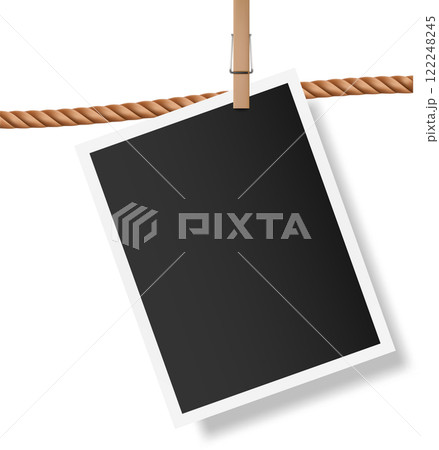 Blank instant photo with white frame hanging on brown rope with wooden clothespin, isolated on white background, creating vintage memories concept 122248245