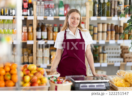 Portrait of positive female seller behind the counter of grocery store 122251547